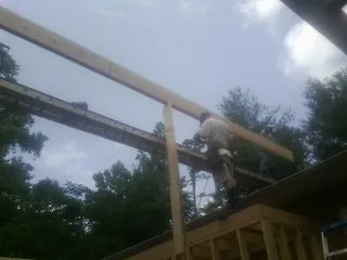 Carpenter setting a ridge beam over a new addition frame — Ice Dam Removal by Roofing Brothers in Far Rockaway